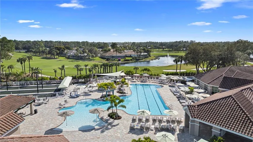 Community pool with view of golf course, a water view, and a patio area