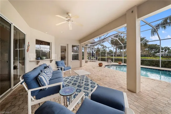 View of patio / terrace with a sunroom, a ceiling fan, an outdoor pool, a lanai, and outdoor lounge area
