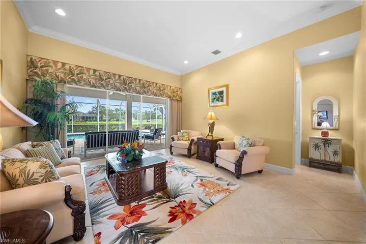 Living room featuring light tile patterned floors, recessed lighting, and ornamental molding
