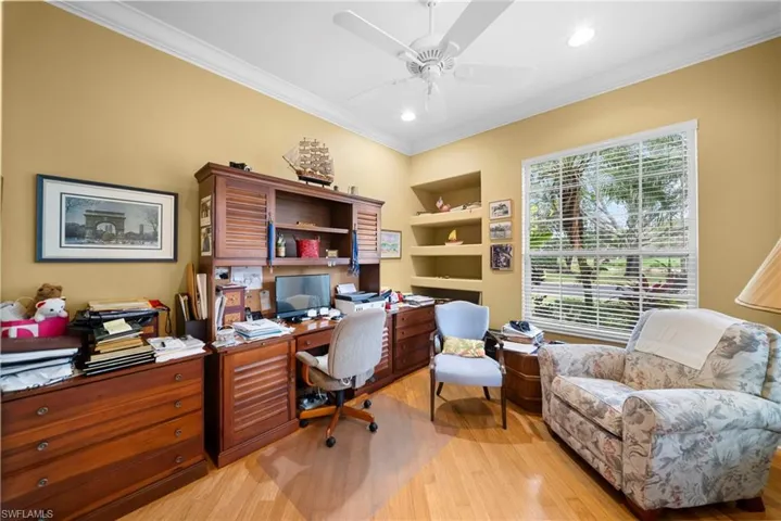 Home office featuring crown molding, light wood-style flooring, recessed lighting, ceiling fan, and built in features