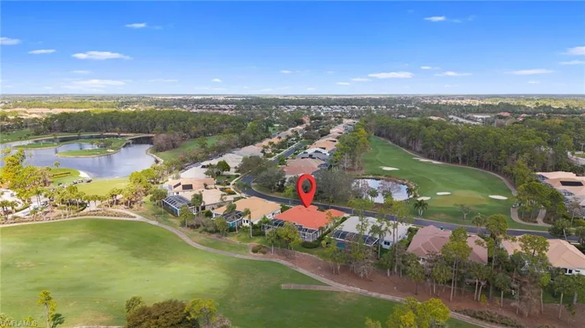 Aerial view of residential area with a local golf course and a large body of water