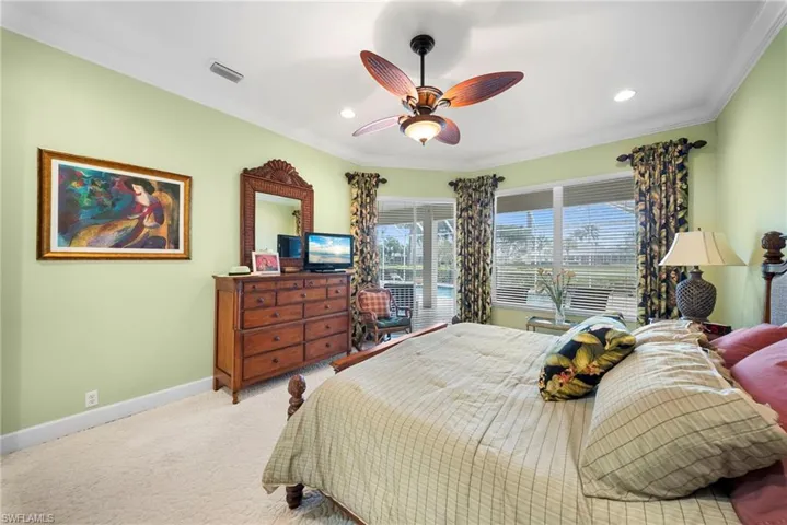 Carpeted bedroom with crown molding, ceiling fan, and recessed lighting