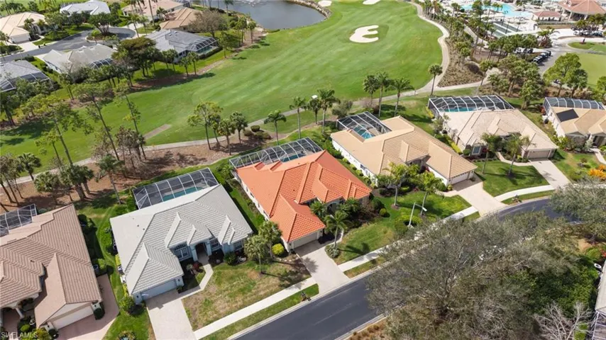 Aerial view of residential area with a golf course and a nearby body of water