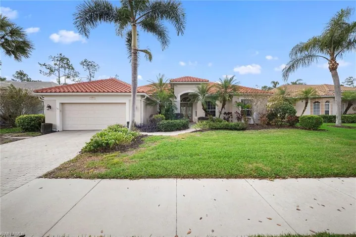 Mediterranean / spanish-style house featuring decorative driveway, an attached garage, stucco siding, and a front yard