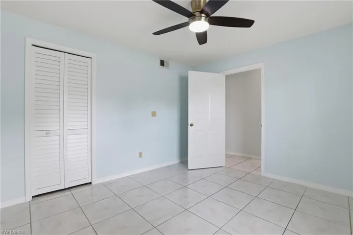 Unfurnished bedroom with a closet, ceiling fan, and light tile patterned flooring