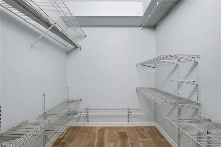 Walk in closet featuring wood finish floors