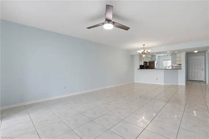 Unfurnished living room with suspended lighting, a ceiling fan, and light tile patterned flooring