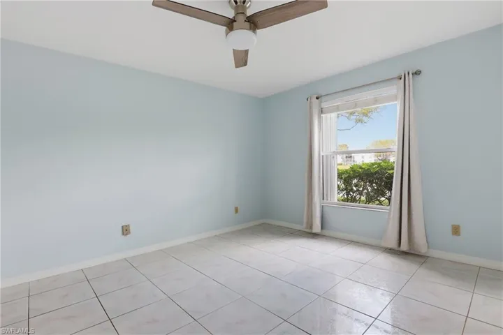 Empty room featuring ceiling fan and light tile patterned flooring