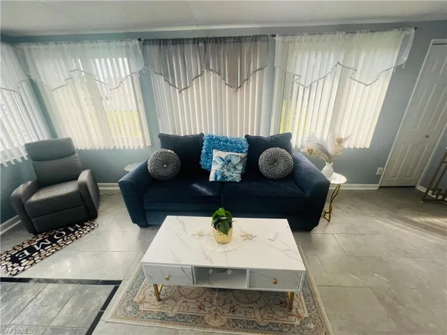 Tiled living area featuring baseboards