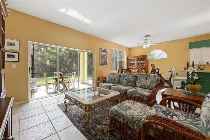 Open-concept interior featuring tile flooring, vaulted ceilings, and a ceiling fan