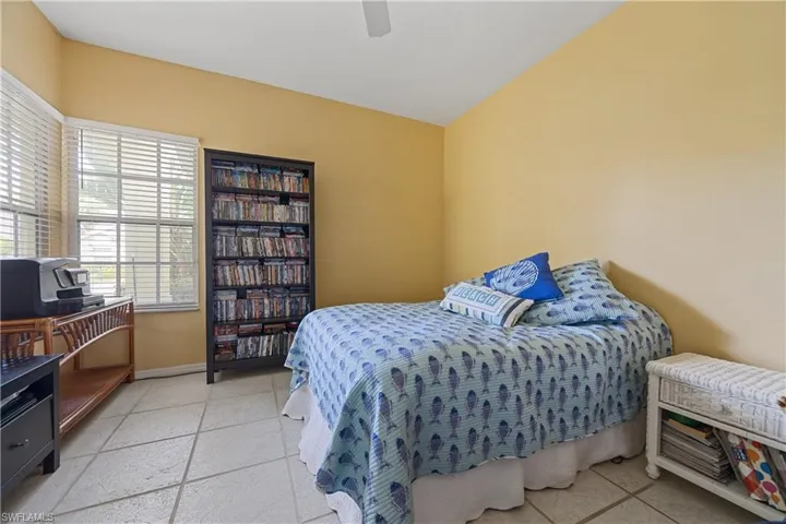 Light-filled room featuring large windows with blinds, a ceiling fan, and square tile flooring