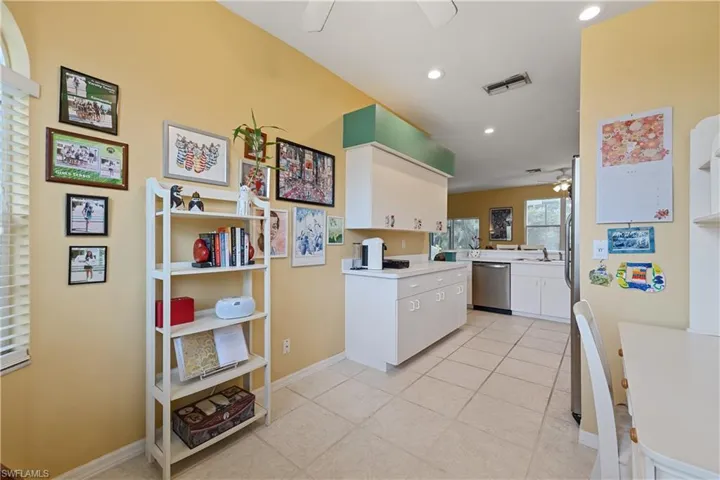 Kitchen area featuring recessed lighting, white cabinetry, stainless steel appliances, and square tile flooring