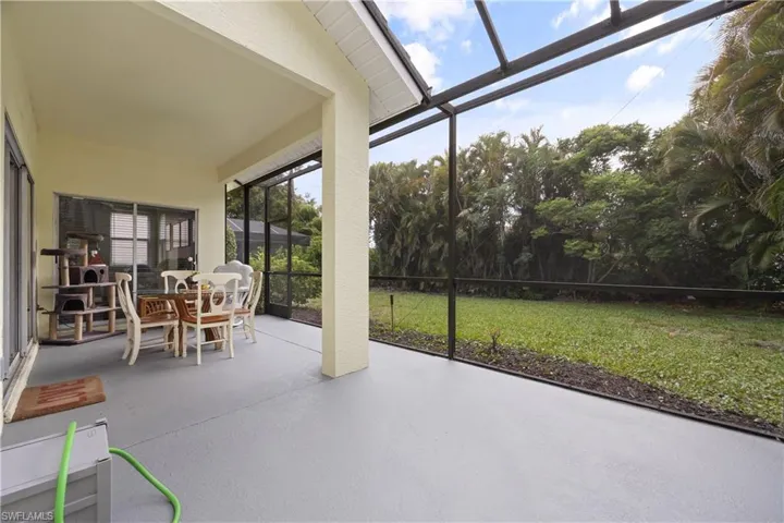 Screened lanai with a painted concrete floor, offering an expansive outdoor living area