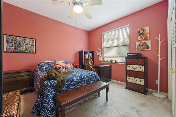Interior space featuring a ceiling fan with integrated lighting, a window with horizontal blinds, and wall-to-wall carpeting
