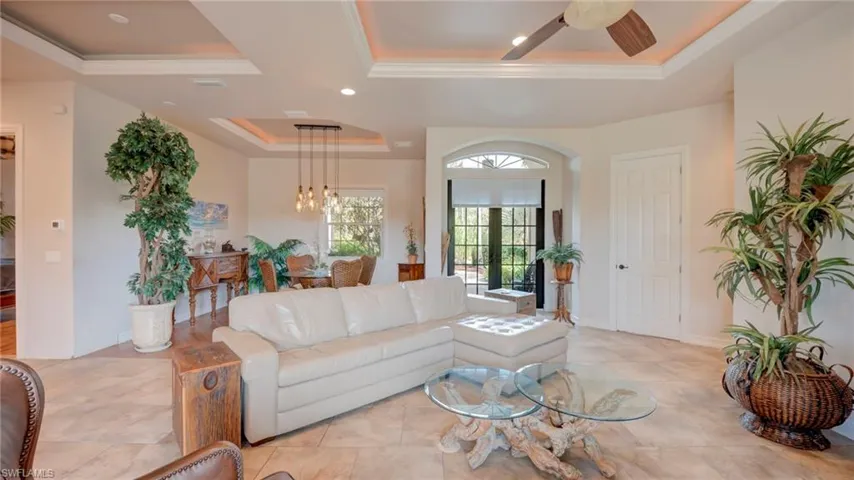 Living area featuring a tray ceiling, french doors, recessed lighting, and ceiling fan