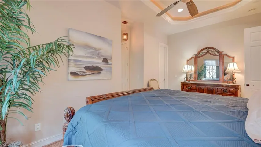 Primary Bedroom with ceiling fan, a raised ceiling, and crown molding