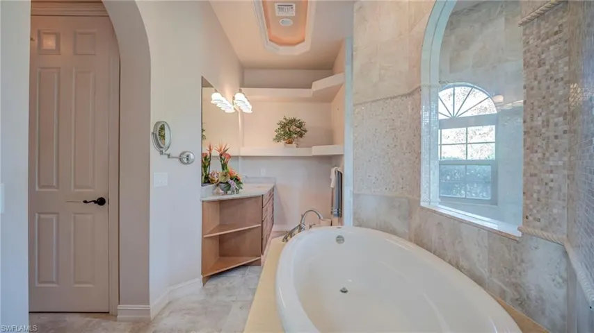 Primary Bathroom featuring vanity and a bath