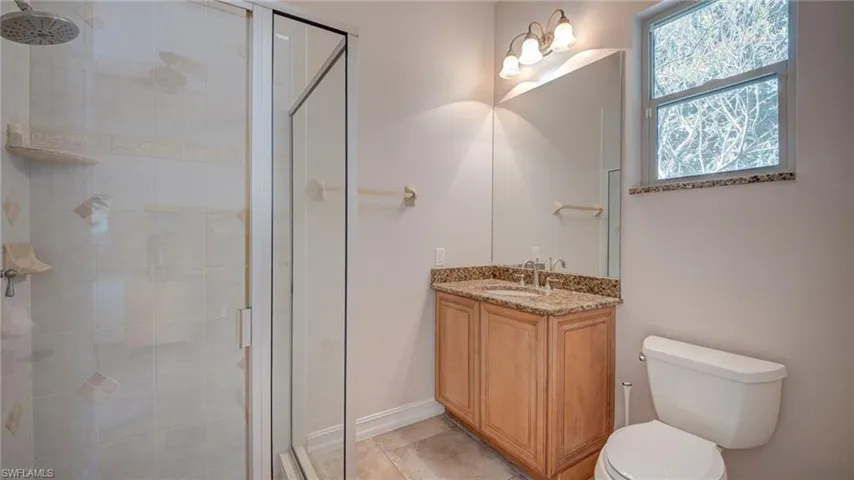 Full bathroom featuring a shower stall and vanity in office area