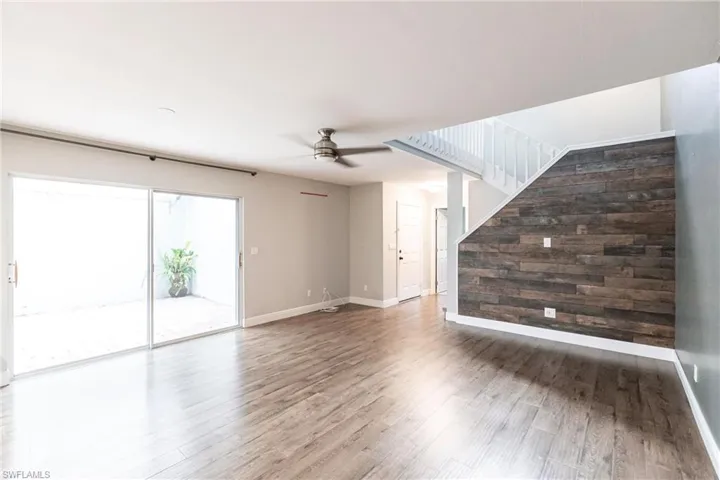 Unfurnished living room with wood-type flooring and ceiling fan