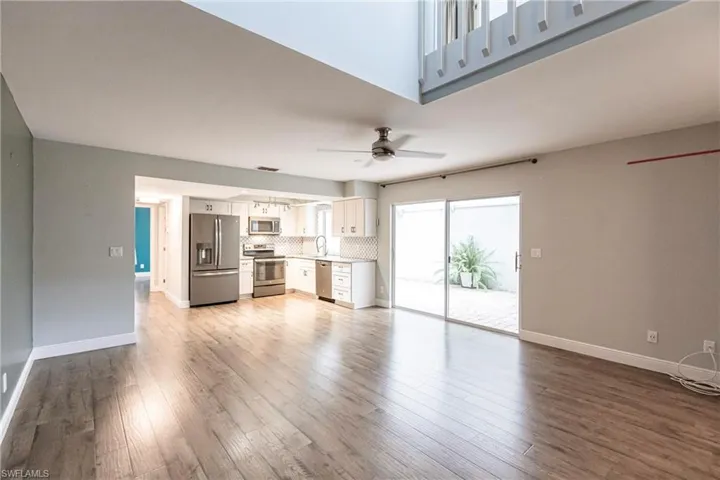 Unfurnished living room with ceiling fan, light wood-type flooring, and sink