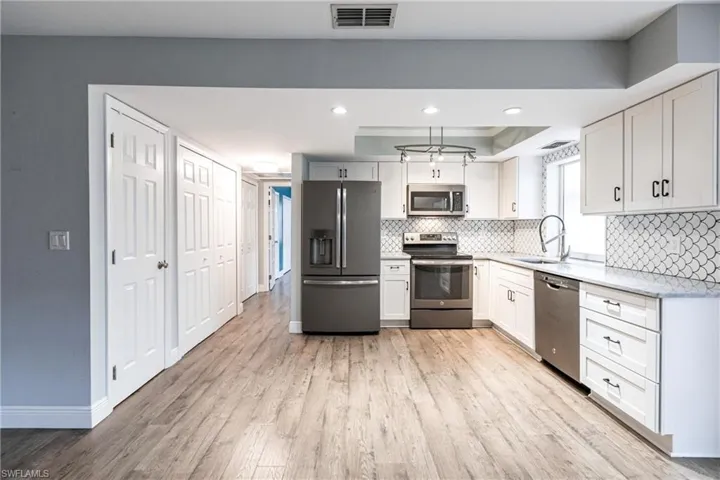 Kitchen featuring white cabinetry, sink, and appliances with stainless steel finishes