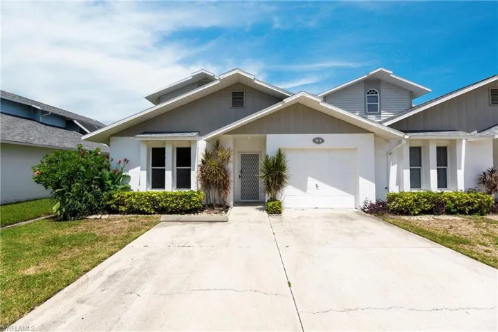 View of front of property with a garage and a front lawn