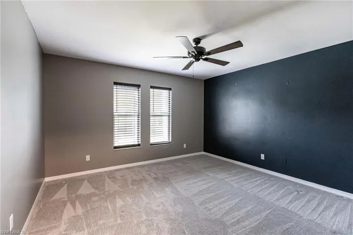Unfurnished room featuring ceiling fan and carpet