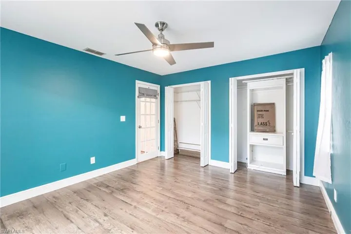 Unfurnished bedroom featuring two closets, ceiling fan, and light hardwood / wood-style floors