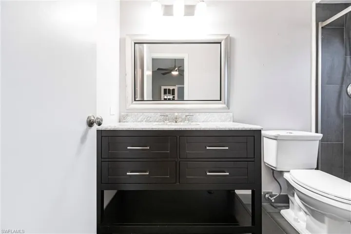 Bathroom featuring ceiling fan, toilet, and vanity