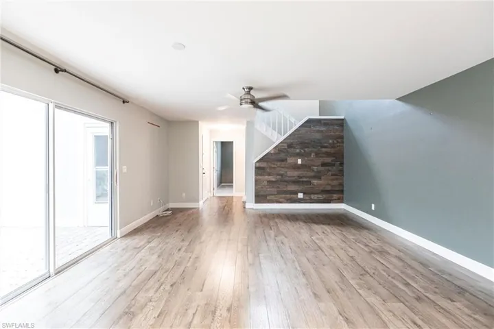 Unfurnished living room featuring ceiling fan and light hardwood / wood-style floors