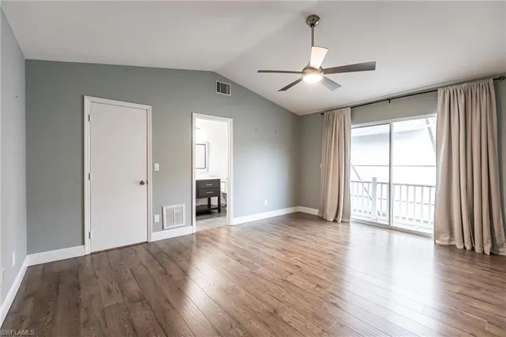 Unfurnished living room featuring ceiling fan, lofted ceiling, and hardwood / wood-style flooring