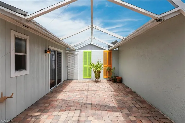 View of patio featuring a lanai
