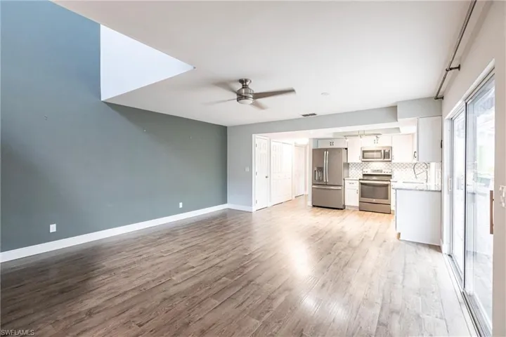 Unfurnished living room with ceiling fan and light hardwood / wood-style flooring