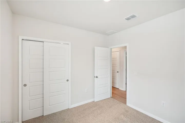 Unfurnished bedroom with a closet and light colored carpet