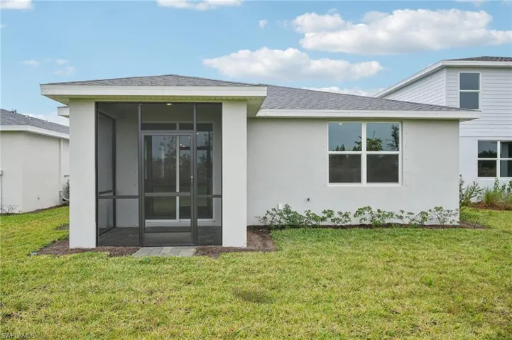 Rear view of property featuring a sunroom and a yard
