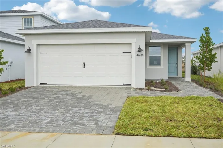 View of front facade featuring a front lawn and a garage