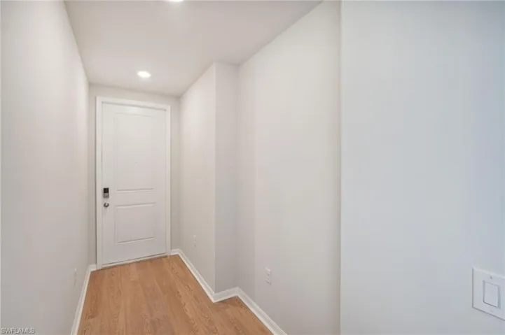 Hall with light hardwood / wood-style flooring