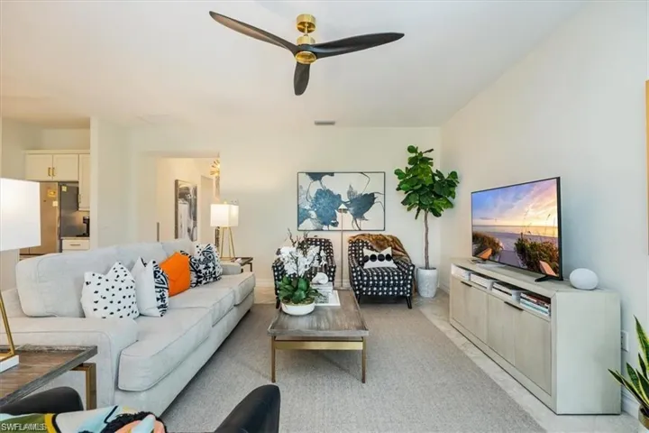 Living area featuring a ceiling fan and light tiles