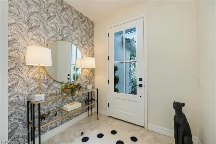 Doorway to outside with wallpapered walls and tile patterned flooring