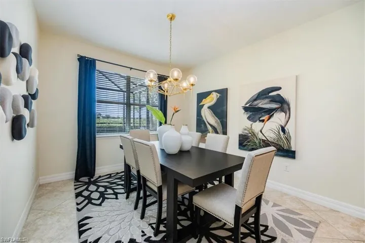 Dining room with light tile patterned floors and a chandelier
