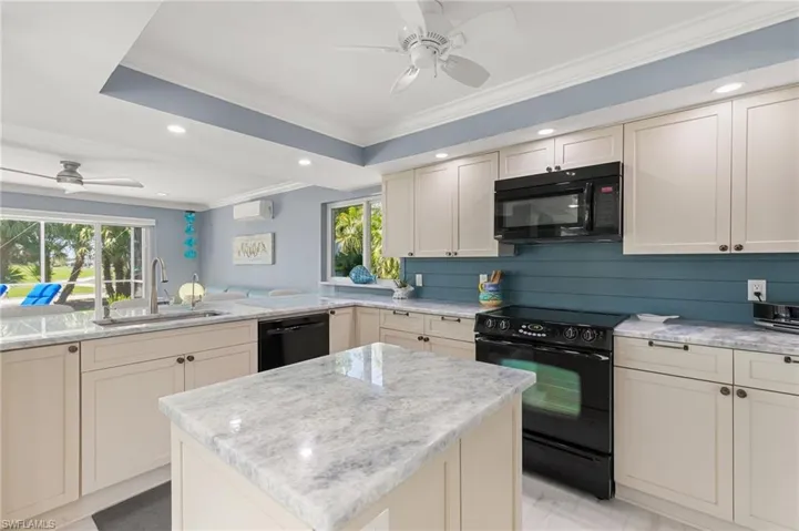 Kitchen with ceiling fan, black appliances, plenty of natural light, and a sink