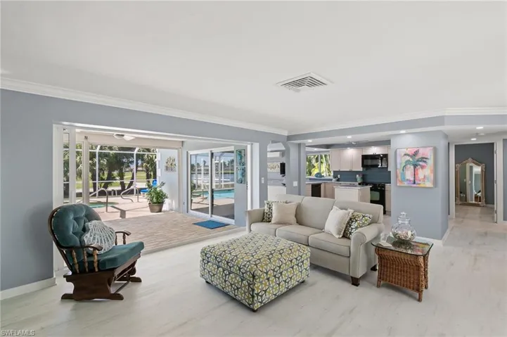 Living area featuring a wealth of natural light, visible vents, and ornamental molding
