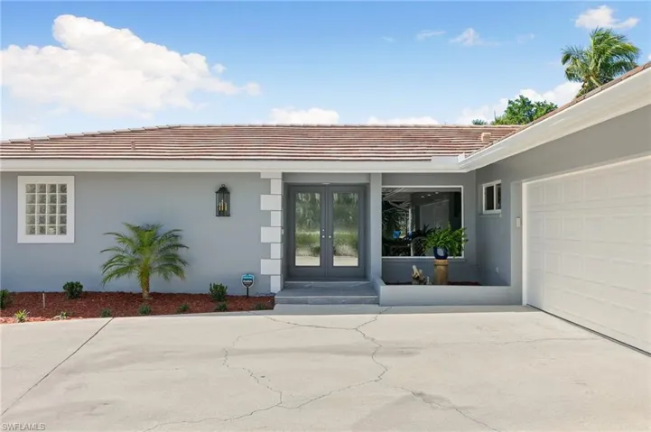 Doorway to property with a tile roof, french doors, and stucco siding
