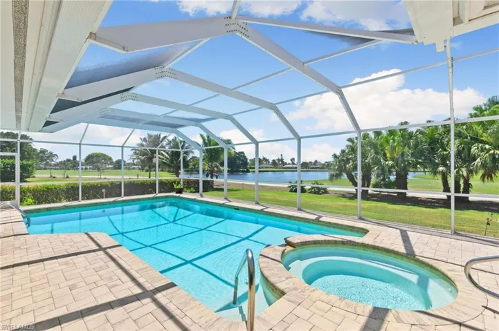 View of swimming pool featuring a water view, a pool with connected hot tub, a yard, a lanai, and a patio area