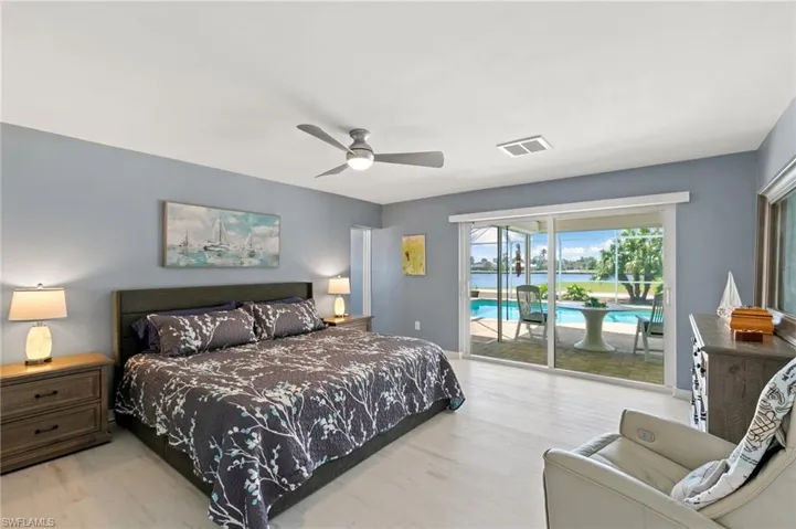Bedroom with access to exterior, wood finished floors, visible vents, and ceiling fan