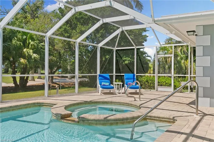 View of pool with a patio area, a lanai, and a pool with connected hot tub