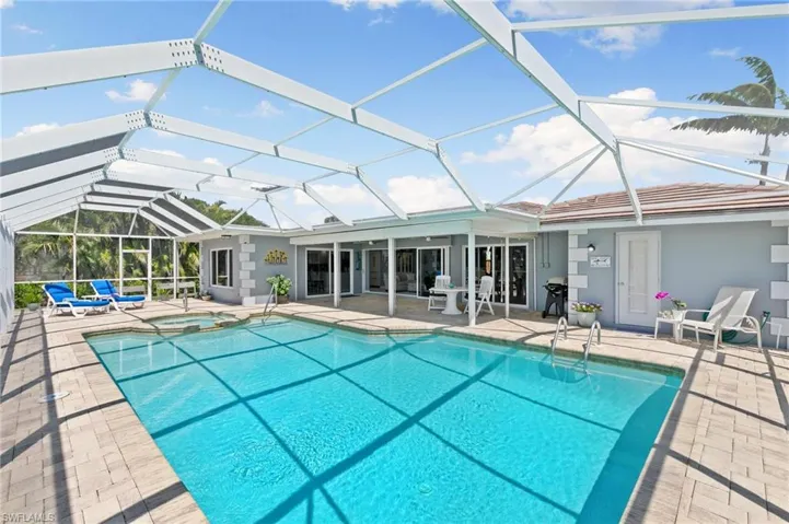 View of swimming pool featuring a patio area, a lanai, and a pool with connected hot tub