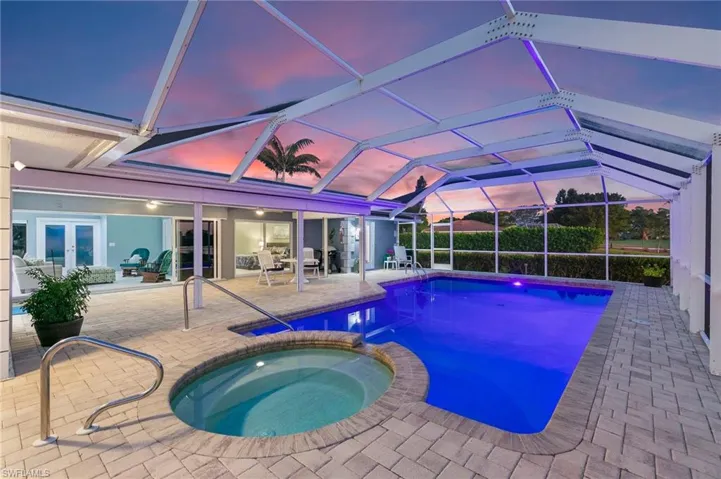 View of pool with a lanai, french doors, a pool with connected hot tub, and a patio