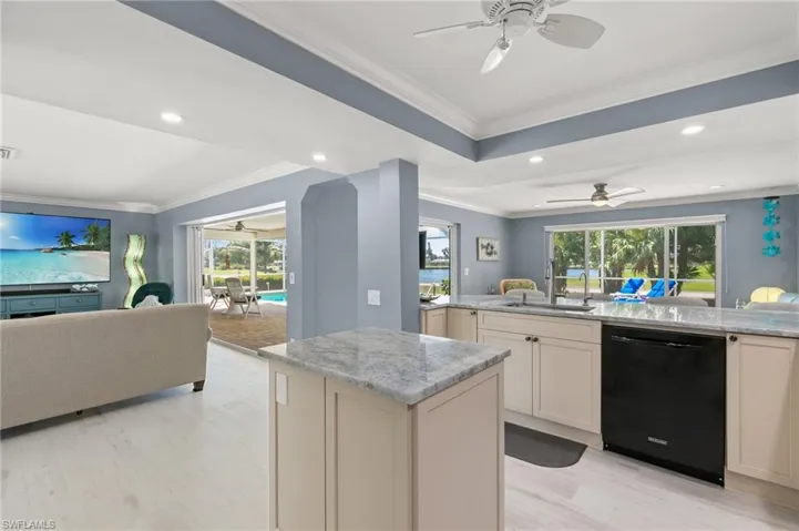Kitchen with a sink, dishwasher, open floor plan, and ceiling fan