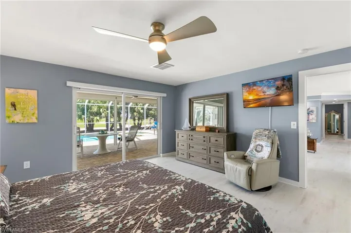 Bedroom with visible vents, access to outside, wood finished floors, baseboards, and ceiling fan